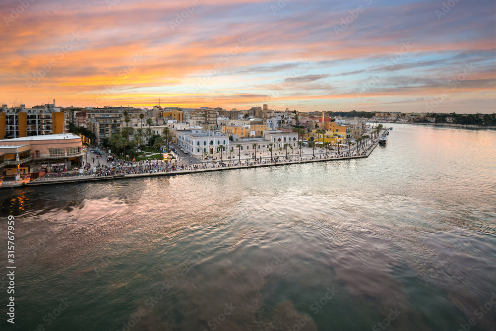 View from a cruise ship as the Piazza Vittorio Emanuele II fills with tourists enjoying a late summer evening sunset at the port city, Brindisi Italy