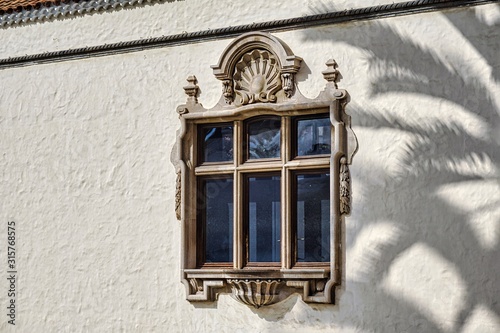 Fotografía mullioned window in whitewashed building in the sun, with the shadow of a large