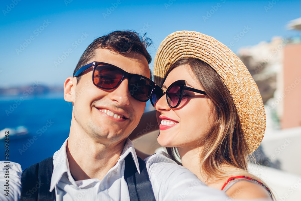 Valentines day. Couple in love taking selfie during honeymoon in Santorini island, Greece. People walking in Thera. Valentines day. Couple in love taking selfie during honeymoon in Santorini island, Greece. People walking in Thera.