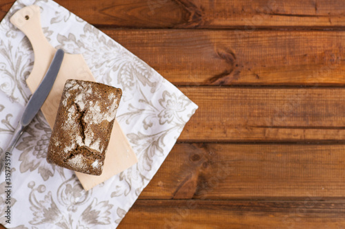 rustic rye bread on a wooden table, flat lay on photo