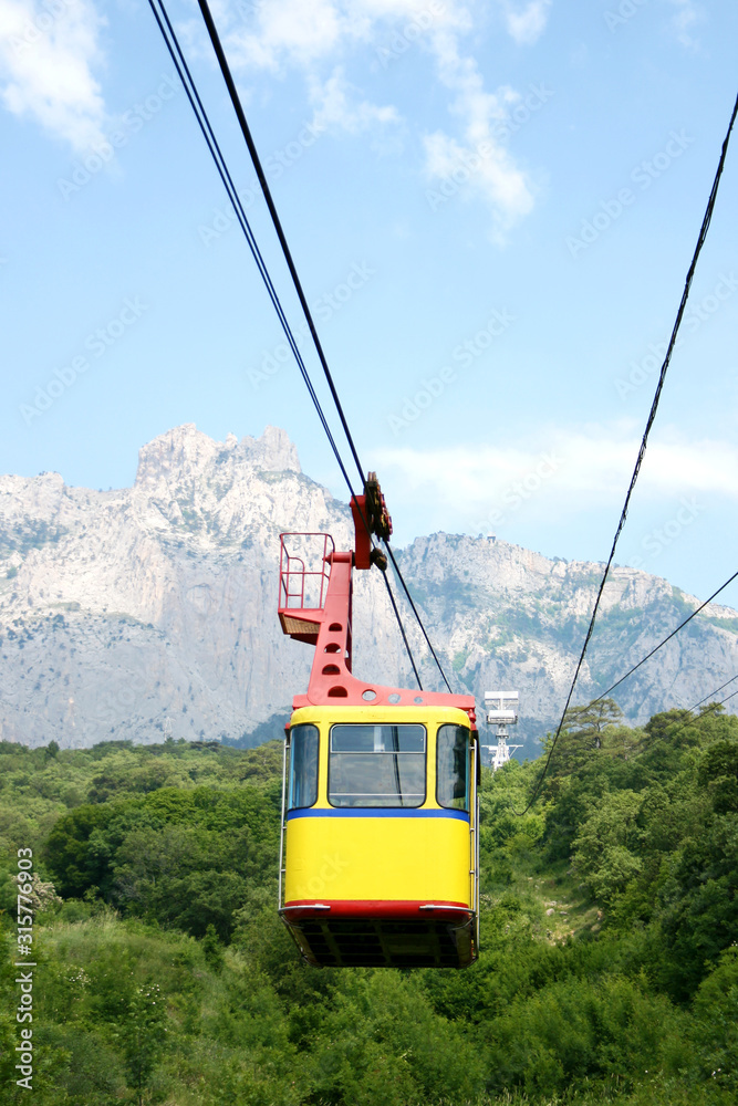 Cable car cabin on a mountain background. The rise of the cable car to the mountains in the summer