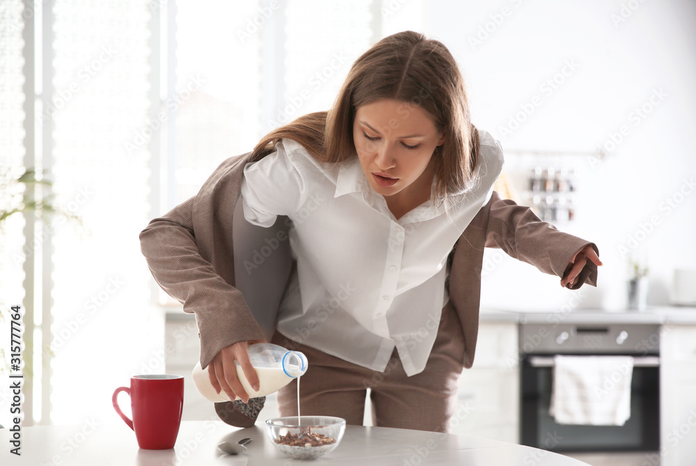 Φωτογραφία Young woman cooking breakfast in hurry at home