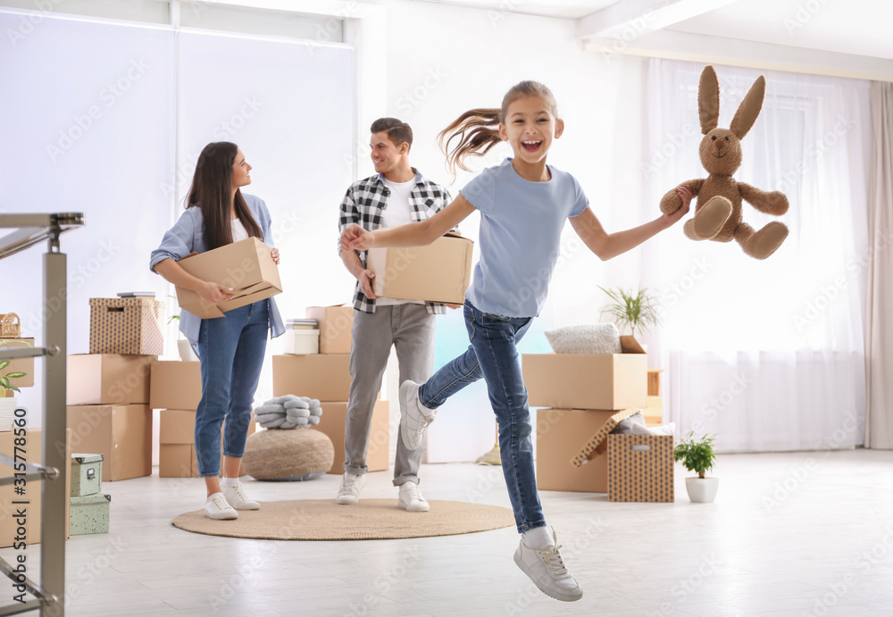 Fototapeta premium Happy family in room with cardboard boxes on moving day