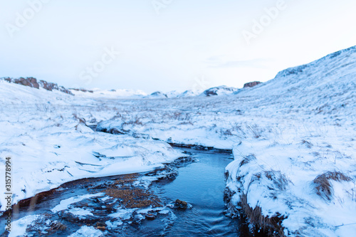 Incredible winter landscape of Iceland. In winter, a source of hot water flows in the mountains