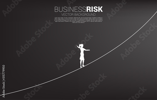 Silhouette of businesswoman walking on rope walk way.Concept for business risk and career path