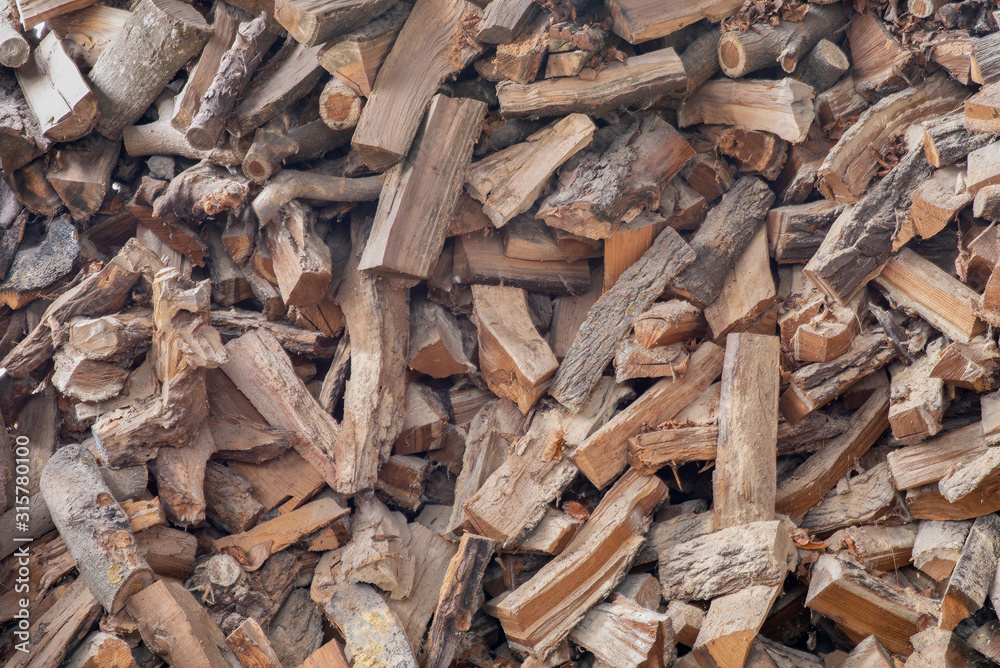 Chopped firewood on a stack. Background of dry chopped firewood logs in a pile. Texture, wallpaper. Chopped firewood on a stack. Background of dry chopped firewood logs in a pile. Texture, wallpaper.