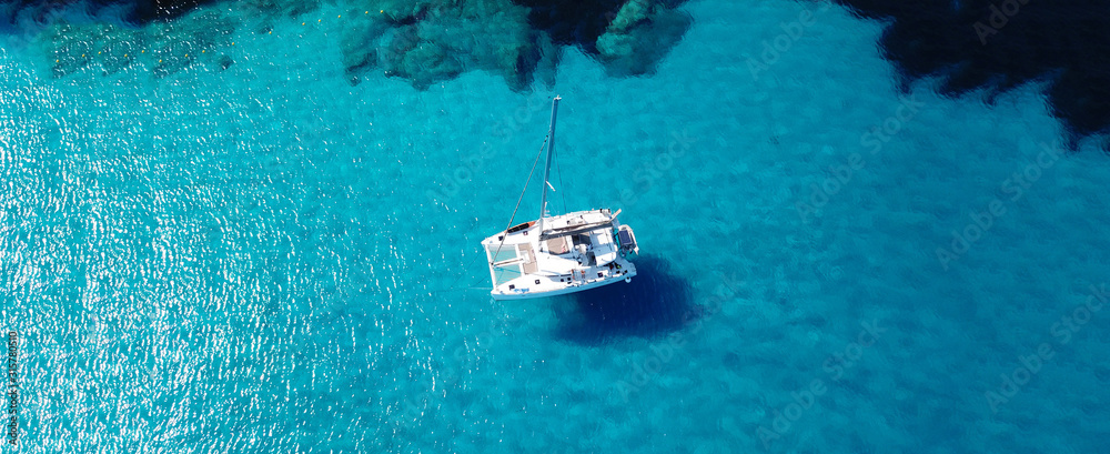 Aerial drone ultra wide photo of sailing yacht anchored in paradise turquoise sea exotic island destination