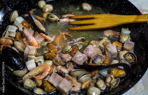 cooking seafood in a pan on a fire