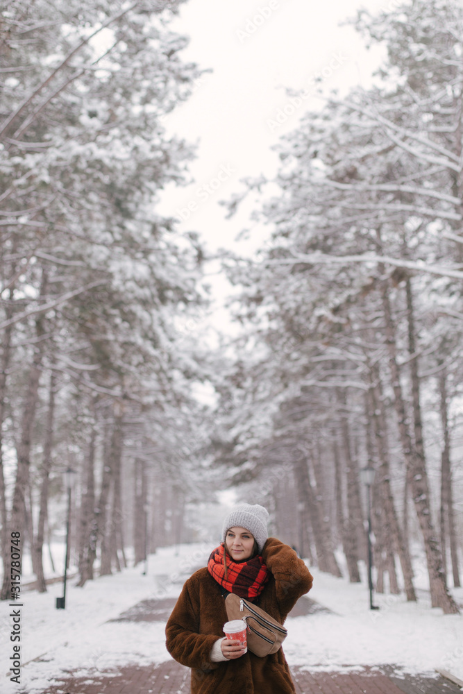 Woman drinking coffee in winter snow forest. Woman drinking coffee in winter snow forest.