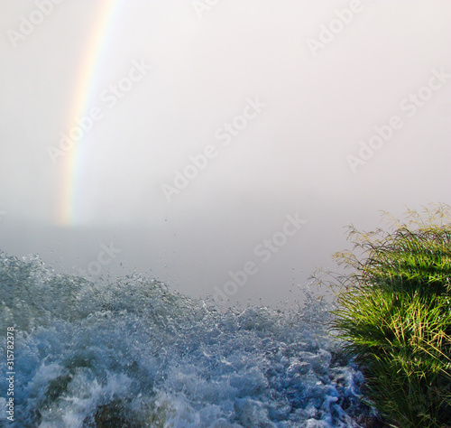 rainbow in the mist over the spray of a waterfall