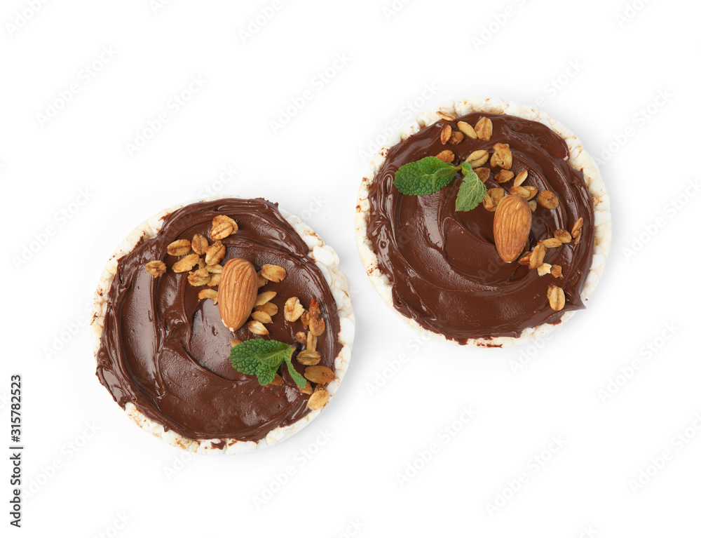 Puffed rice cakes with chocolate spread, nuts and mint isolated on white, top view Puffed rice cakes with chocolate spread, nuts and mint isolated on white, top view