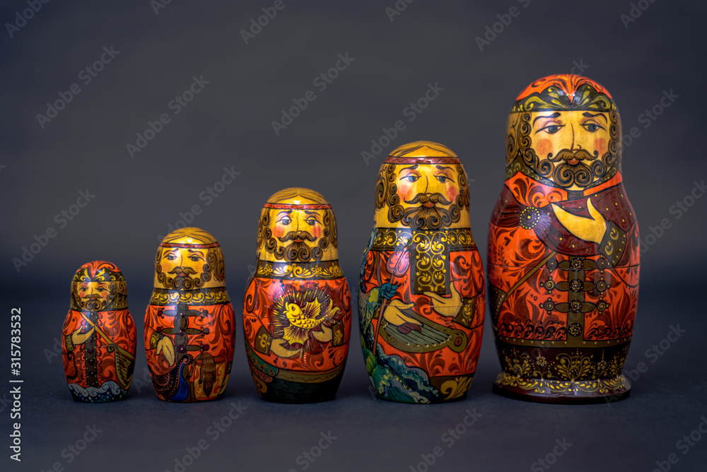 Traditional Russian matryoshka dolls lined up against gray background, doll within a doll, object within an object, metaphor for shell companies, Russian nesting doll 6 Traditional Russian matryoshka dolls lined up against gray background, doll within a doll, object within an object, metaphor for shell companies, Russian nesting doll 6