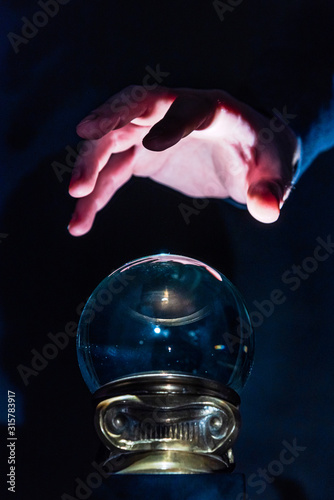 Hand over crystal ball in dark room  crystal ball gazing  crystal ball psychic  crystal ball fortune telling  crystal ball scrying  crystal ball object of power  seance with crystal ball 3