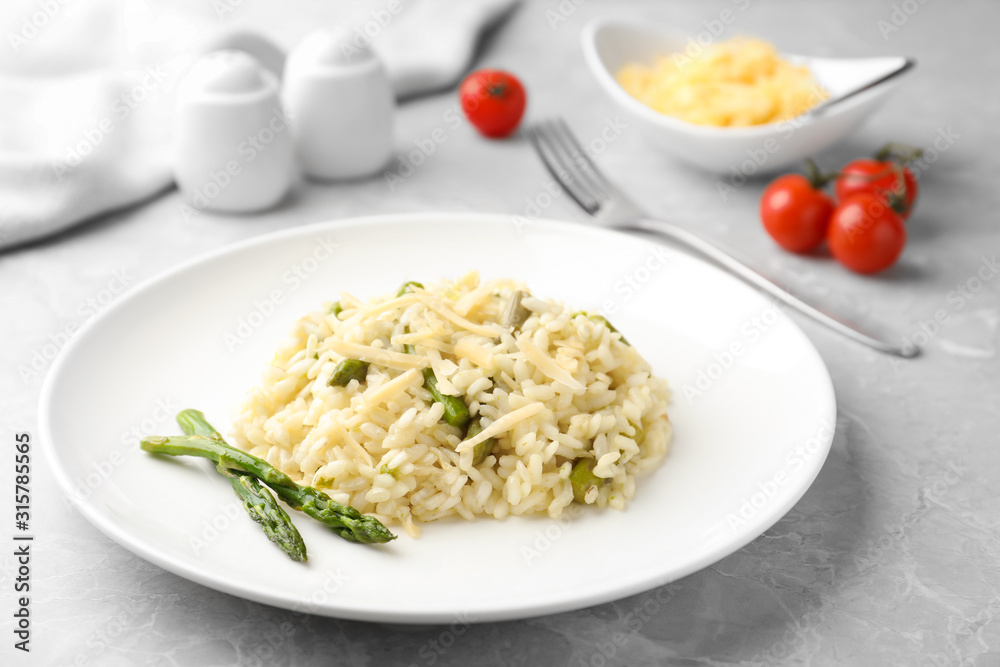 Delicious risotto with asparagus on grey marble table