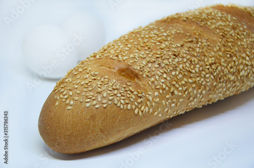  fresh baguette with sesame seeds on a white background