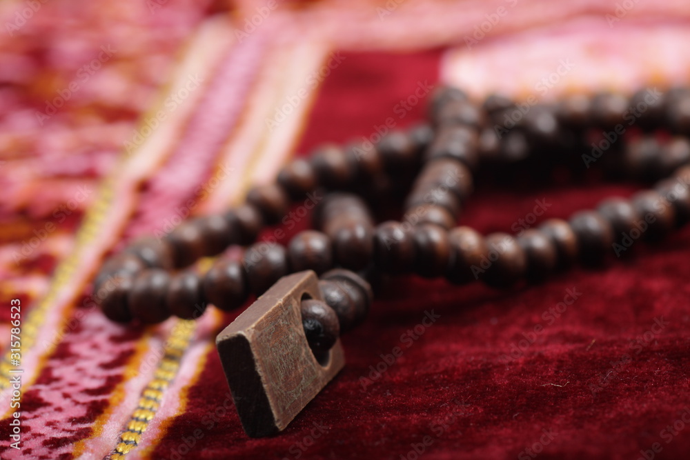 Close up shoot of a Praying beads on a sajadah (Carpet for moslem praying) Close up shoot of a Praying beads on a sajadah (Carpet for moslem praying)