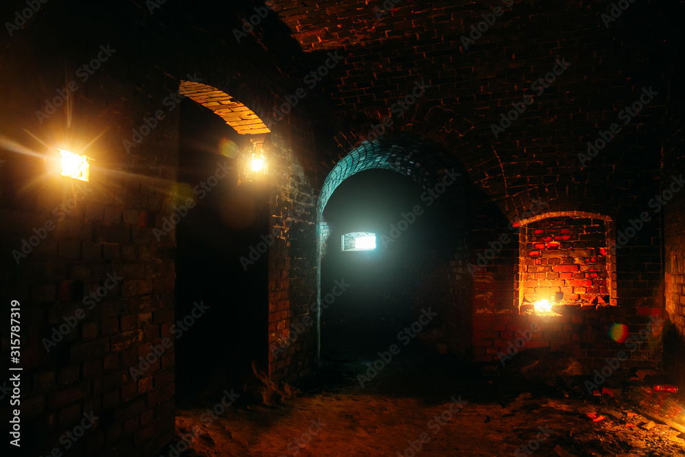 Dark dungeon under the old german fortress illuminated by candles