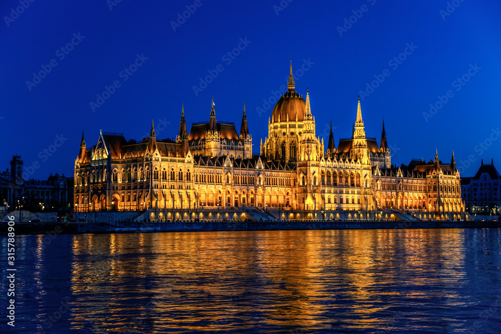 Hungarian Parliament Building (Orsaghaz) at night with illumination on the Danube River, Hungary.