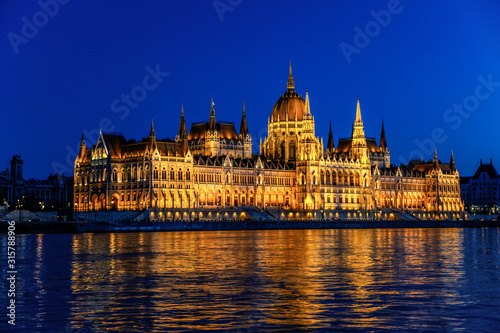 Hungarian Parliament Building (Orsaghaz) at night with illumination on the Danube River, Hungary.