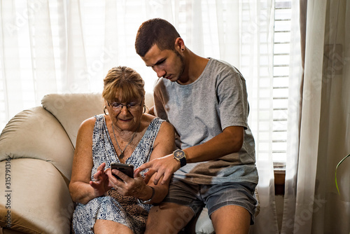 grandson helping his grandmother with smartphone photo