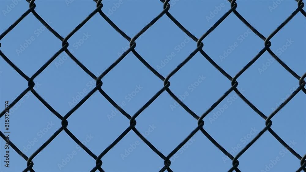 Camera sliding around the wired fence with blue sky close up Camera sliding around the wired fence with blue sky close up