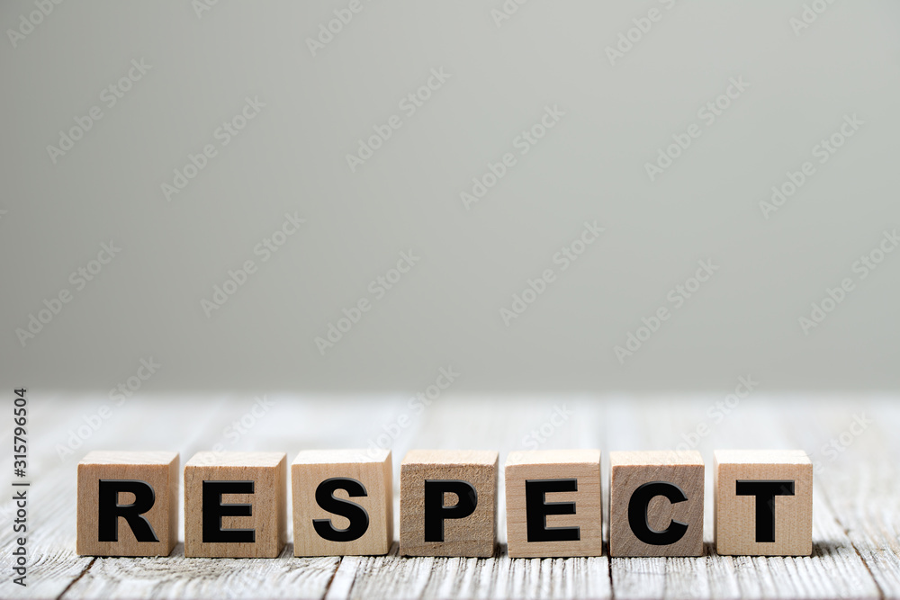 Respect word written on wood block on wooden background - obrazy, fototapety, plakaty 