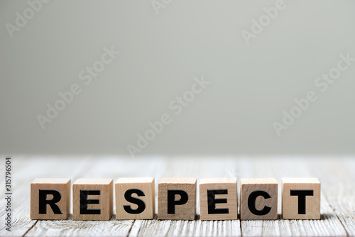 Respect word written on wood block on wooden background