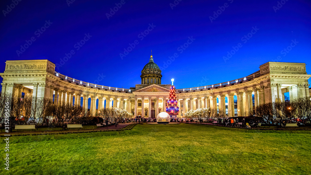 Night view of russian orthodox church Kazan Cathedral with New Year's fir-tree at snowless winter on Nevsky Prospect. Saint-Petersburg, Russia.