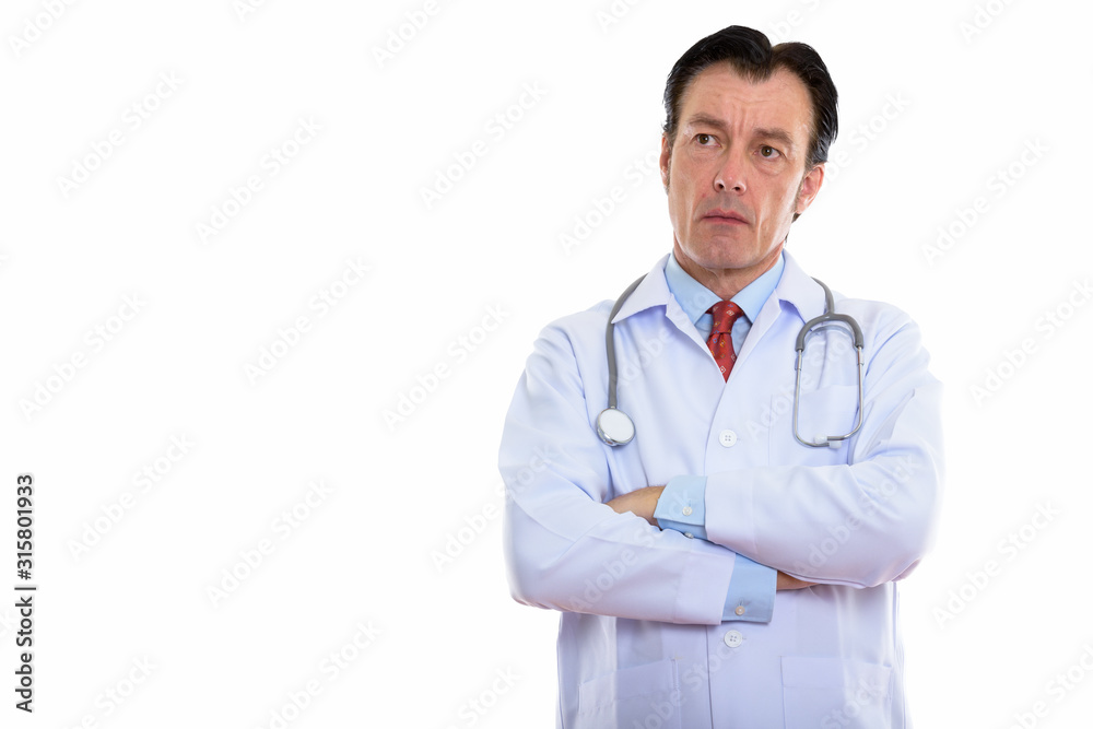Studio shot of mature handsome man doctor thinking with arms crossed Studio shot of mature handsome man doctor thinking with arms crossed