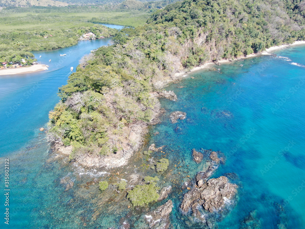 Lush Tropical coastline with rocks and blue water in Costa Rica