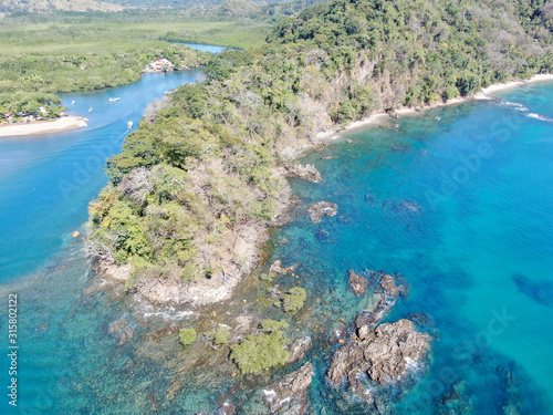 Lush Tropical coastline with rocks and blue water in Costa Rica