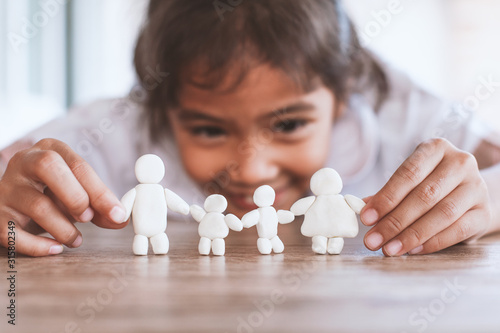 Cute asian child girl playing with plasticine clay happy family with fun. Happy family concept. photo