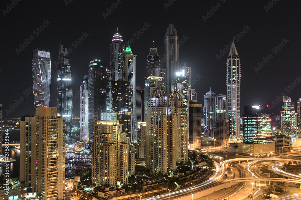 Cityscape and skyline at night in Dubai Marina.