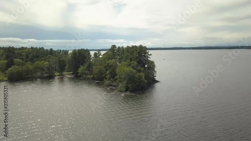 Drone shot going down and around pine trees at Sebago Lake in Maine photo