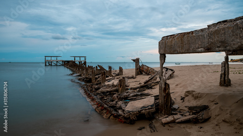 Dilapidated old fishing dock collapsing into the sea in Pak Nam Pran Thailand photo