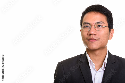 Studio shot of young Asian businessman wearing eyeglasses while