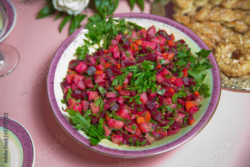 Fresh homemade Beetroot salad Vinaigrette in a white bowl. Vegetable salad with beets on table ready for eat . beetroot salad with Carrots, Pickles and green Onion in white plate .