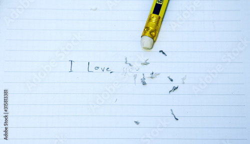 I love you in a notebook written in pencil. It has been partially deleted.