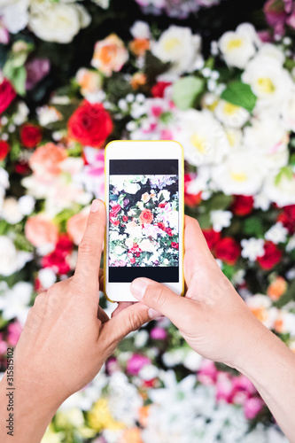 Man taking photo of flowers with a smartphone