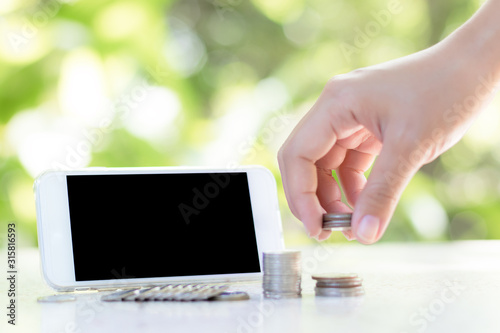 The coin handle has a mobile phone on the back and has a natural background. photo