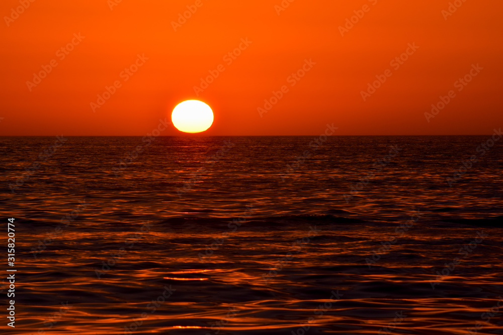 Red sunset sunrise over ocean sea. Beautiful Sunrise. Glowing sea sunrise. Atlantic Sunset in  Florida, USA.