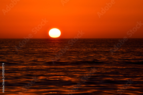 Red sunset sunrise over ocean sea. Beautiful Sunrise. Glowing sea sunrise. Atlantic Sunset in Florida, USA.