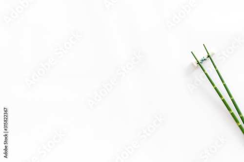 Chopsticks - green wooden utensil for sushi and rolls - on white background top-down copy space