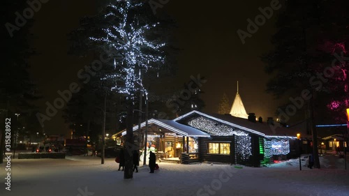 Happy tourists walking in Rovaniemi, a small touristic town, in Finland at night
