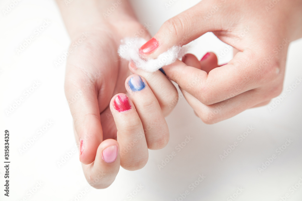 Hands remove the manicure on fingernails. Hands remove the manicure on fingernails.