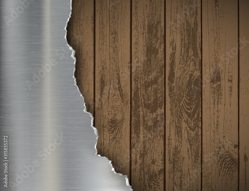 Metal silver torn plate on a wooden background.