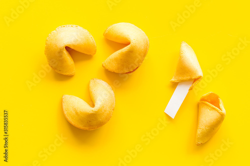 Traditional fortune cookies on yellow table top-down