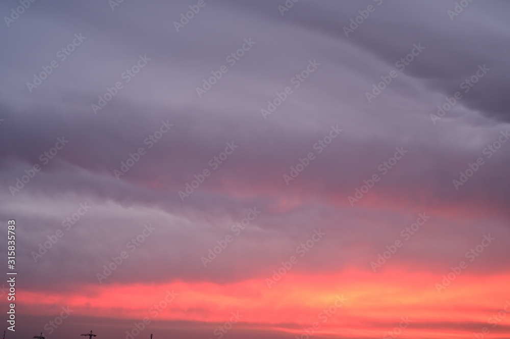Photo of a gloomy sky colororg at sunrise over the city
