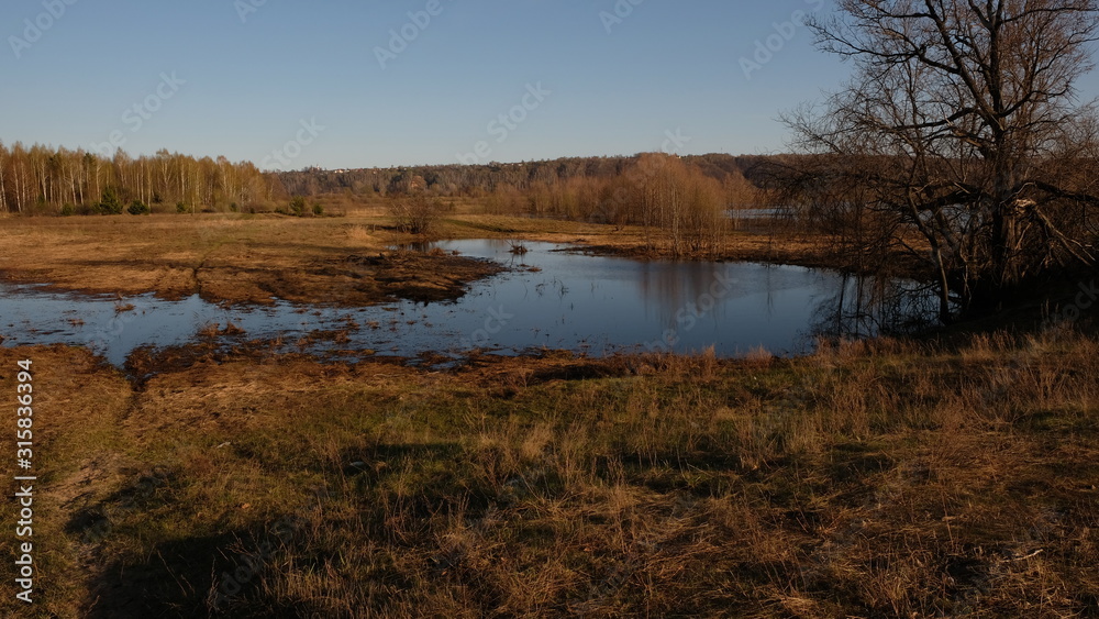 Flooding on the river in early spring in rural areas. Inundation. Naked earth after winter.