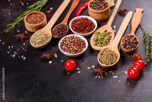 Fototapeta Naklejka Na Ścianę i Meble -  A set of spices and herbs. Indian cuisine. Pepper, salt, paprika, basil and other on a dark background
